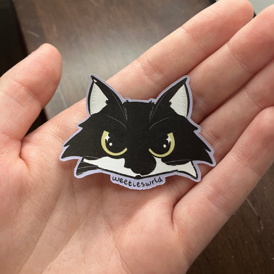 Black and white cat sticker with yellow eyes, lavender outline, and text reading "Weetieswrld".